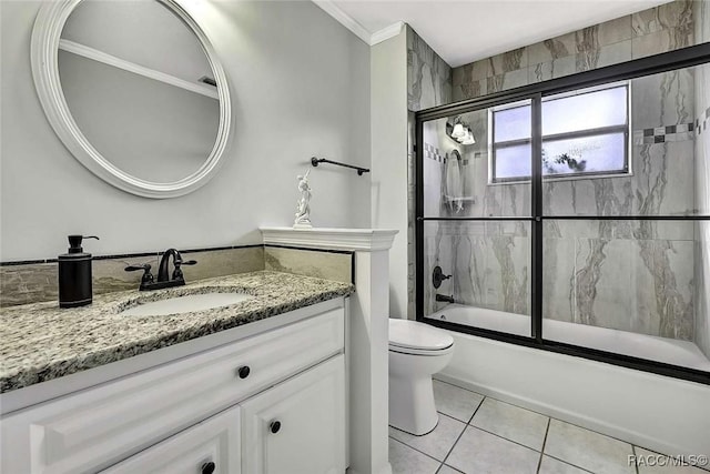 bathroom with vanity, ornamental molding, tile patterned floors, toilet, and combined bath / shower with glass door