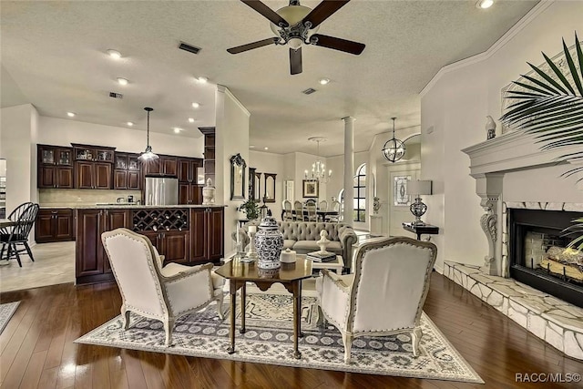 interior space featuring a high end fireplace, visible vents, dark wood-style flooring, and a textured ceiling