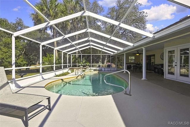 pool with glass enclosure, french doors, and a patio