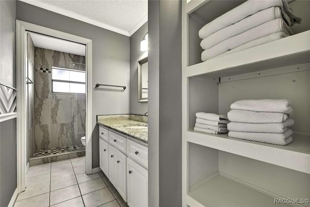 bathroom featuring toilet, a textured ceiling, crown molding, tiled shower, and vanity