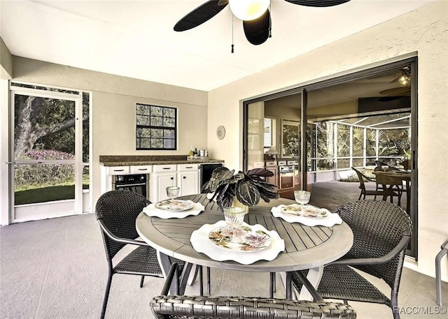 interior space featuring a textured wall, ceiling fan, and a sunroom