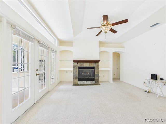 unfurnished living room with visible vents, baseboards, ceiling fan, a tiled fireplace, and carpet flooring