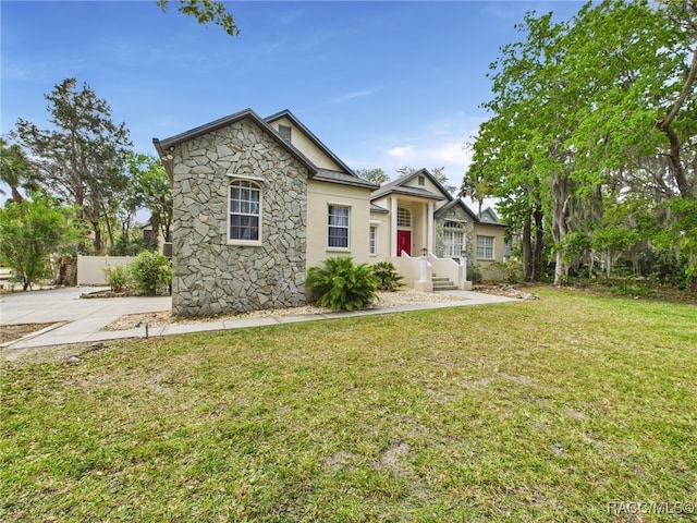 view of front of property featuring a front lawn and stone siding