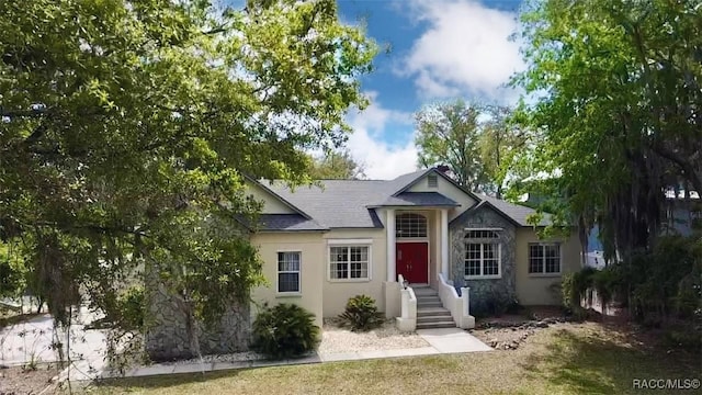 ranch-style home with roof with shingles and stucco siding
