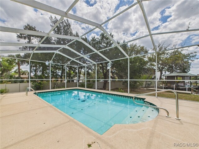 outdoor pool with a lanai and a patio