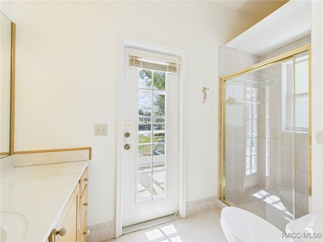 full bathroom featuring vanity, tile patterned flooring, a stall shower, and toilet