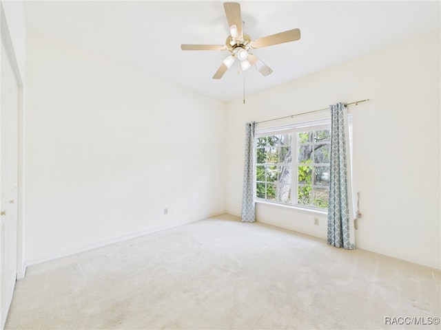 carpeted empty room featuring a ceiling fan