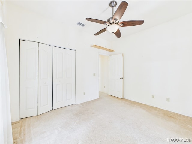 unfurnished bedroom with a ceiling fan, visible vents, carpet, and a closet