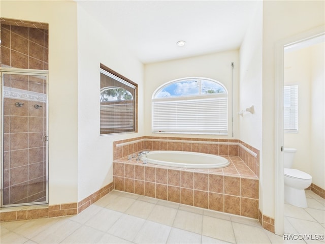 bathroom featuring tile patterned floors, a stall shower, toilet, and a garden tub