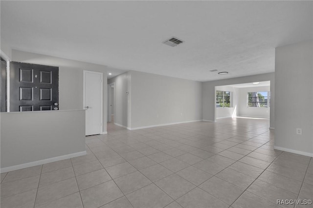 spare room featuring light tile patterned flooring, visible vents, and baseboards