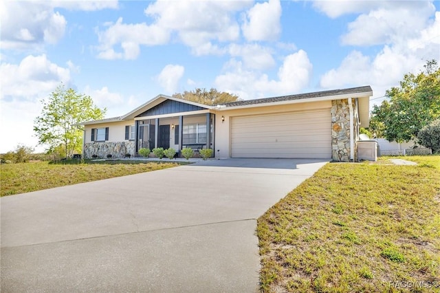 single story home featuring a garage, concrete driveway, and a front yard