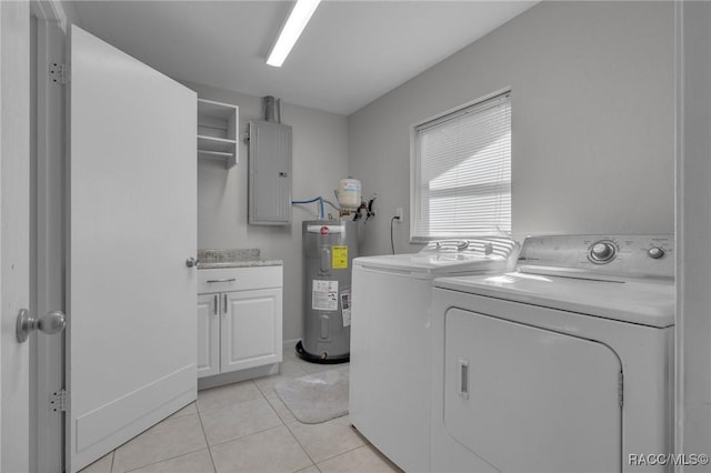 washroom featuring washer and clothes dryer, electric panel, water heater, cabinet space, and light tile patterned floors