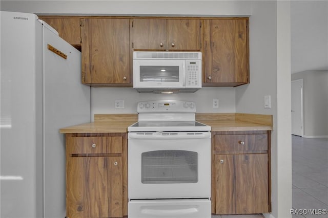 kitchen with brown cabinetry, white appliances, and light countertops