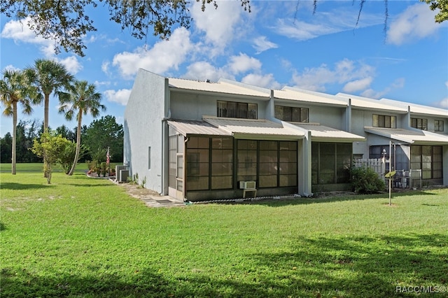 back of house with a lawn, a sunroom, and cooling unit