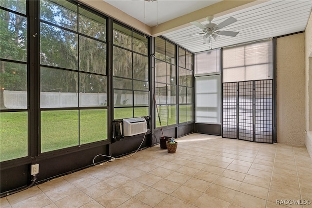 unfurnished sunroom with ceiling fan, beam ceiling, and cooling unit