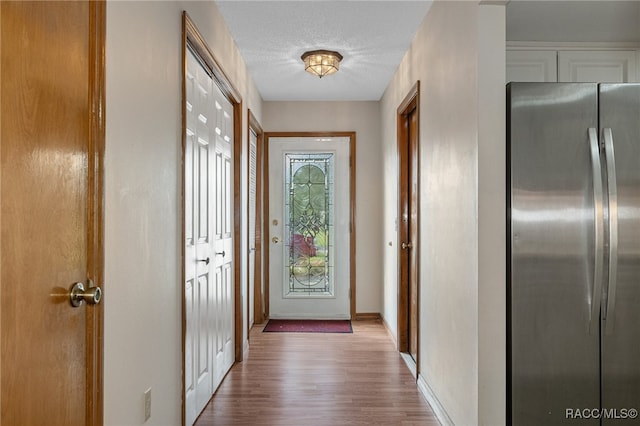 entryway with a textured ceiling and hardwood / wood-style flooring