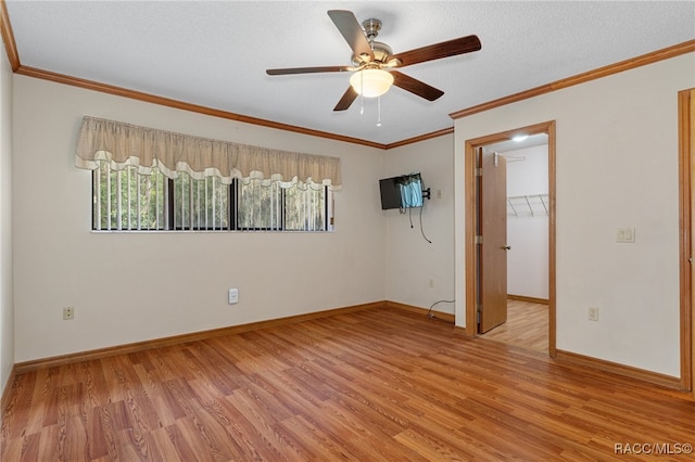 spare room featuring ceiling fan, ornamental molding, a textured ceiling, and light hardwood / wood-style flooring