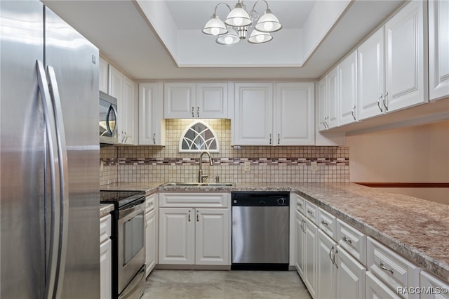 kitchen with white cabinetry, sink, hanging light fixtures, a raised ceiling, and appliances with stainless steel finishes