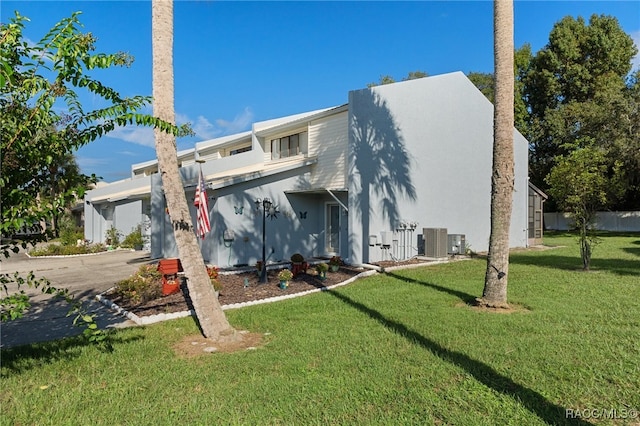 view of front of property featuring central AC, a front lawn, and a garage