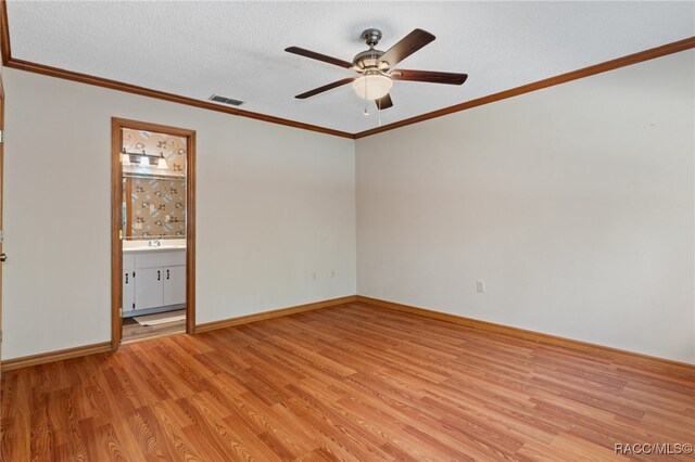 empty room with ceiling fan, crown molding, a textured ceiling, and light hardwood / wood-style flooring