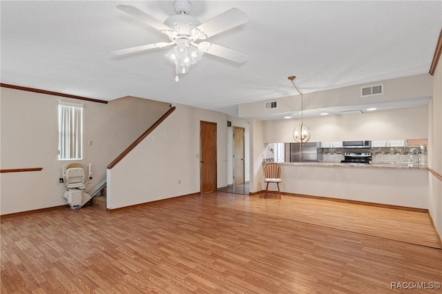 unfurnished living room with ceiling fan, crown molding, a textured ceiling, and light hardwood / wood-style flooring