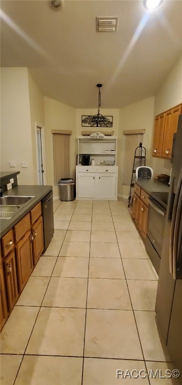 7689 N Galt Pt, Citrus Springs, FL 34434 - kitchen with vaulted ceiling, dark countertops, stove, brown cabinets, and light tile patterned floors
