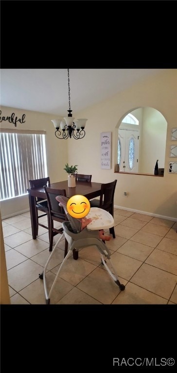 7689 N Galt Pt, Citrus Springs, FL 34434 - dining room with healthy amount of natural light, light tile patterned floors, arched walkways, and a chandelier