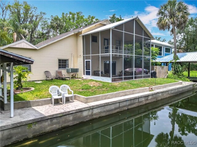 857 N Palm Springs Ter, Crystal River, FL 34429 - back of house featuring a sunroom, a water view, and a lawn
