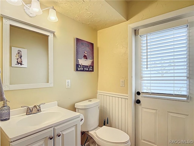 857 N Palm Springs Ter, Crystal River, FL 34429 - bathroom featuring toilet, vanity, and a wainscoted wall
