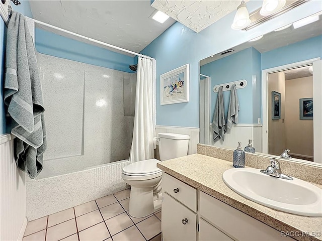 857 N Palm Springs Ter, Crystal River, FL 34429 - full bathroom featuring toilet, tile patterned floors, vanity, shower / bath combo with shower curtain, and a wainscoted wall