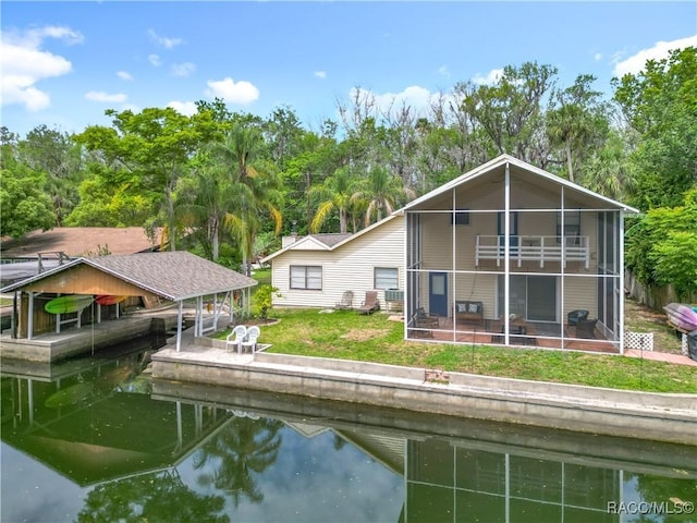 857 N Palm Springs Ter, Crystal River, FL 34429 - rear view of property with a water view, boat lift, a lawn, and a sunroom
