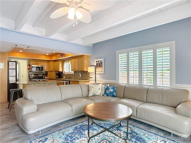 857 N Palm Springs Ter, Crystal River, FL 34429 - living area featuring beamed ceiling, a ceiling fan, a wainscoted wall, and light wood-type flooring