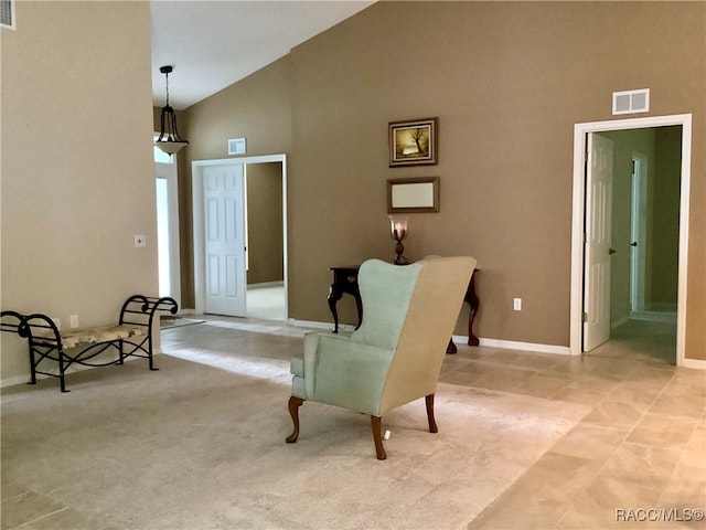 living area featuring light carpet and high vaulted ceiling