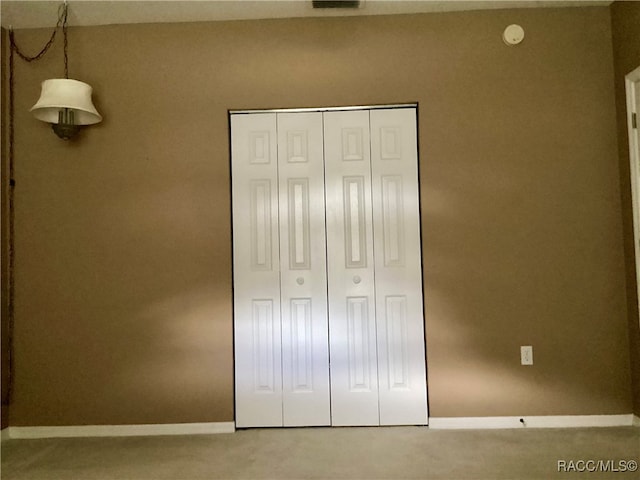 unfurnished bedroom featuring carpet flooring and a closet