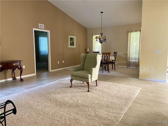 living area with high vaulted ceiling and a notable chandelier