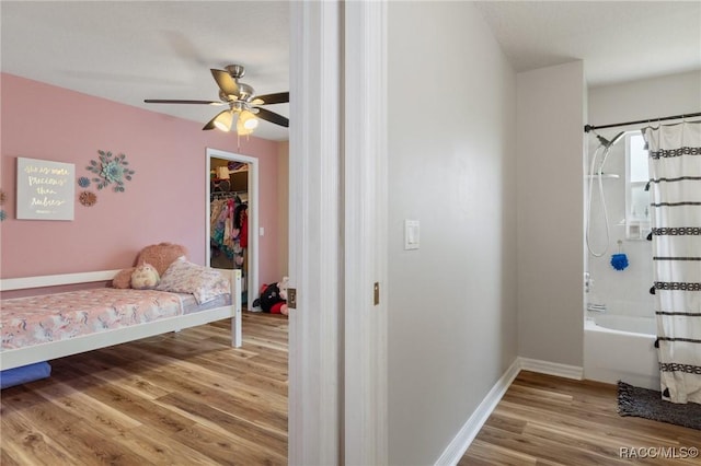 bedroom featuring hardwood / wood-style flooring, a walk in closet, ensuite bathroom, and a closet