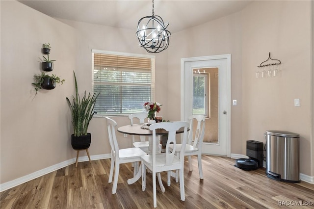 dining space featuring wood-type flooring and a chandelier