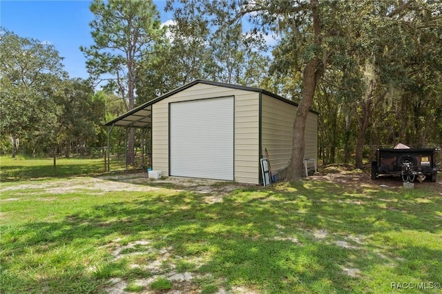 view of outdoor structure with a garage and a lawn