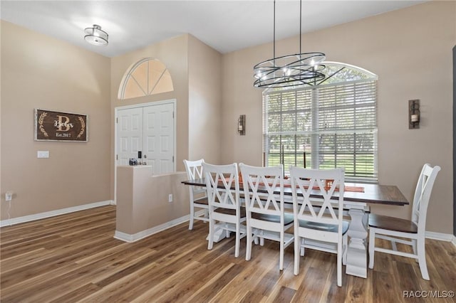 dining space with wood-type flooring and a chandelier