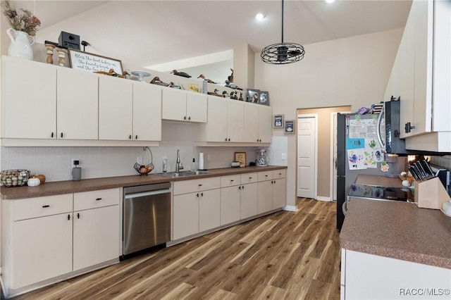 kitchen with sink, dark hardwood / wood-style flooring, pendant lighting, stainless steel appliances, and white cabinets