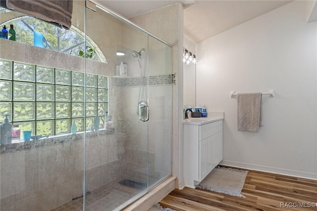 bathroom featuring vanity, a healthy amount of sunlight, hardwood / wood-style floors, and walk in shower