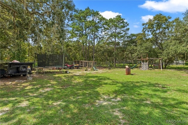 view of yard featuring a playground and a trampoline