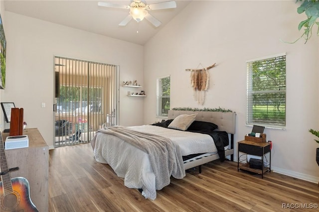 bedroom featuring hardwood / wood-style flooring, ceiling fan, access to exterior, and high vaulted ceiling