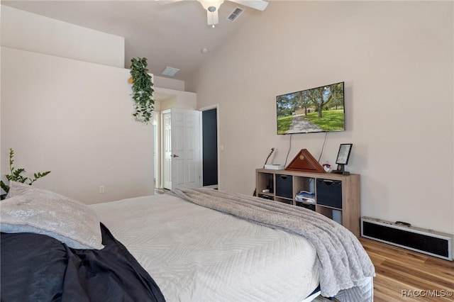 bedroom with ceiling fan, wood-type flooring, and high vaulted ceiling