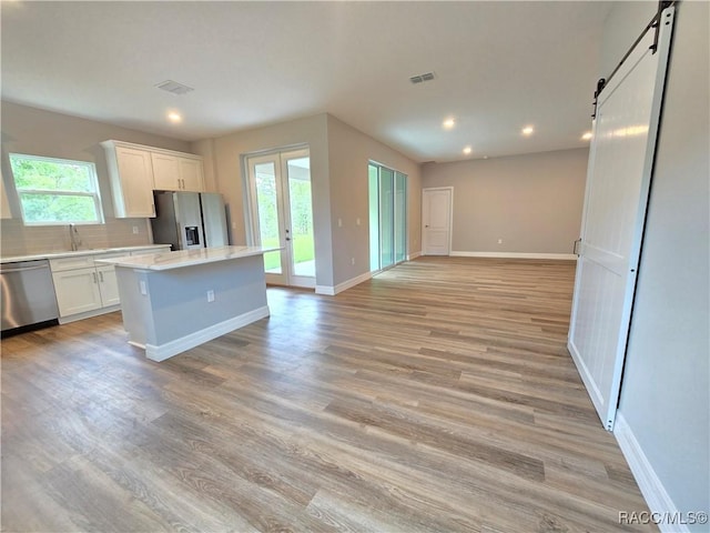 8 Calendula Ct, Homosassa, FL 34446 - kitchen with stainless steel appliances, a kitchen island, a barn door, open floor plan, and backsplash