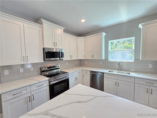 8 Calendula Ct, Homosassa, FL 34446 - kitchen featuring appliances with stainless steel finishes, a sink, white cabinets, and recessed lighting