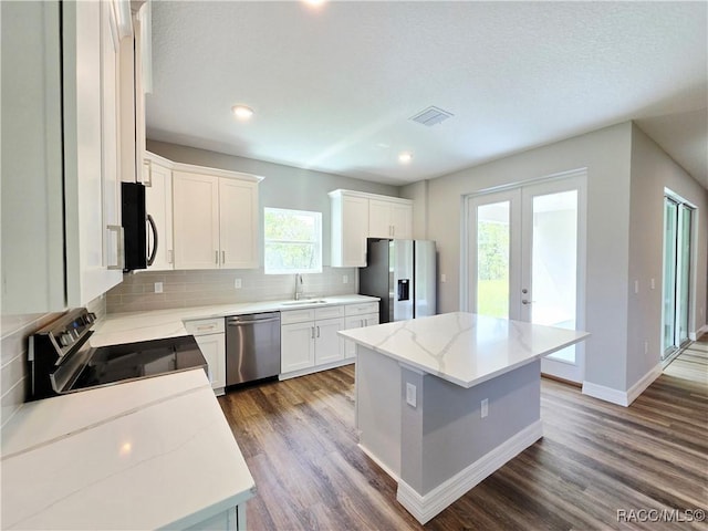 8 Calendula Ct, Homosassa, FL 34446 - kitchen with stainless steel appliances, a sink, a kitchen island, decorative backsplash, and dark wood finished floors