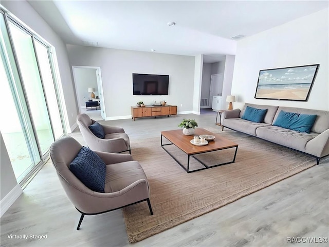 living room featuring wood finished floors, visible vents, and baseboards