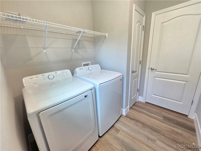 8 Calendula Ct, Homosassa, FL 34446 - washroom featuring washing machine and clothes dryer, light wood-style floors, and baseboards