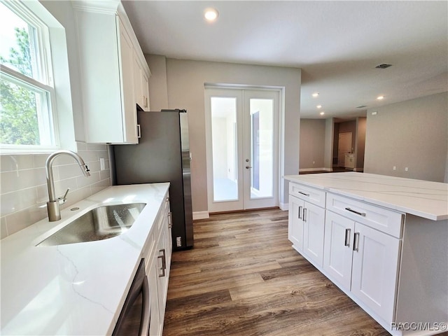 8 Calendula Ct, Homosassa, FL 34446 - kitchen featuring a sink, french doors, white cabinets, wood finished floors, and backsplash